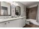 Bathroom featuring double sinks, granite counters, and tiled shower and tub at 265 E Liberty Ln, Gilbert, AZ 85296