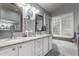 Bathroom with a double sink vanity, granite countertop, and tub with tiled backsplash at 265 E Liberty Ln, Gilbert, AZ 85296