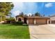 Charming single-story home with a well-manicured lawn and three-car garage at 265 E Liberty Ln, Gilbert, AZ 85296