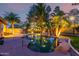 Backyard pool area showcasing a tranquil in-ground pool with rock waterfall feature at dusk at 265 E Liberty Ln, Gilbert, AZ 85296