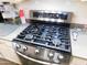 Stainless steel gas stove with digital display, cooktop with four burners, and oven beneath at 265 E Liberty Ln, Gilbert, AZ 85296