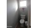 Cozy powder room with a toilet, tiled floors, and a window providing natural light at 265 E Liberty Ln, Gilbert, AZ 85296