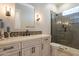 Elegant bathroom features neutral cabinetry, quartz countertops, decorative tile backsplash, and glass-enclosed shower at 28304 N 141St Way, Scottsdale, AZ 85262