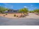 Modern home exterior with desert landscaping, trees, and circular driveway leading to the property at 28304 N 141St Way, Scottsdale, AZ 85262