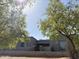 Modern gray home with desert landscaping, featuring a low brick wall and natural vegetation at 28304 N 141St Way, Scottsdale, AZ 85262