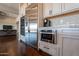 Modern kitchen with stainless steel appliances, white cabinetry, and a gray backsplash at 28304 N 141St Way, Scottsdale, AZ 85262