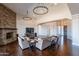 Spacious living room featuring a stone fireplace, hardwood floors, and modern chandeliers at 28304 N 141St Way, Scottsdale, AZ 85262