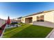 The backyard features artificial turf and a patio area with barbecue grill at 30071 W Indianola Ave, Buckeye, AZ 85396