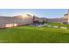 An artificial turf backyard includes a brick patio with a barbecue grill and table at 30071 W Indianola Ave, Buckeye, AZ 85396