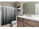 Inviting bathroom features modern fixtures, a toilet, shelving, a large mirror, and a shower with curtain at 30071 W Indianola Ave, Buckeye, AZ 85396