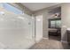 Bright bathroom with a glass-enclosed shower adjacent to the doorway to the bedroom at 30071 W Indianola Ave, Buckeye, AZ 85396