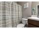 Bathroom featuring a shower with striped curtains, toilet, a white sink with modern fixtures and decor at 30071 W Indianola Ave, Buckeye, AZ 85396