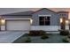 View of the inviting facade of this home featuring a garage and a front yard with decorative rock and desert shrubs at 30071 W Indianola Ave, Buckeye, AZ 85396