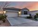 View of the inviting facade of this home featuring a two car garage and a long driveway at 30071 W Indianola Ave, Buckeye, AZ 85396