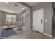 Bright living room showcases tile floors, a desk and chair, and a front door at 30071 W Indianola Ave, Buckeye, AZ 85396