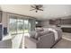 Open living space with a large sofa, sliding glass doors to the patio, and an eat-in kitchen at 30071 W Indianola Ave, Buckeye, AZ 85396