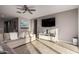 Stylish living room with a large sectional sofa, flat screen tv, ceiling fan, and bright sunlight at 30071 W Indianola Ave, Buckeye, AZ 85396