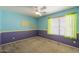 This carpeted bedroom includes a ceiling fan and a window, enhanced by an eye-catching color combination at 303 W Thompson Pl, Chandler, AZ 85286