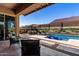 Beautiful backyard featuring a pool with a water feature, lounge furniture, and desert mural at 3202 N 197Th Ave, Buckeye, AZ 85396