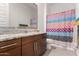 Bathroom featuring dark wood cabinets, granite countertops, decorative shower curtain, and tile floors at 3202 N 197Th Ave, Buckeye, AZ 85396