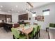 Open dining area with bright green chairs and a modern light fixture adjacent to the kitchen at 3202 N 197Th Ave, Buckeye, AZ 85396