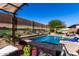 Inviting backyard pool featuring a tanning ledge, relaxing furniture, and vibrant landscaping at 3202 N 197Th Ave, Buckeye, AZ 85396