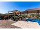 Relaxing poolside area showcasing comfortable seating beneath a pergola and desert mural backdrop at 3202 N 197Th Ave, Buckeye, AZ 85396