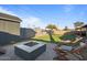 Secluded backyard featuring artificial grass, lounge chairs, a built-in fire pit, and perimeter block fence at 3834 E Shaw Butte Dr, Phoenix, AZ 85028