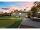 Relaxing backyard featuring artificial grass, a built-in fire pit, patio furniture, and a covered seating area at 3834 E Shaw Butte Dr, Phoenix, AZ 85028
