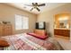 Comfortable main bedroom features a ceiling fan, natural light, and an en-suite bathroom at 41573 W Anne Ln, Maricopa, AZ 85138