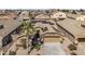 Aerial view of a house with solar panels, desert landscaping, and a spacious driveway at 42660 W Oakland Dr, Maricopa, AZ 85138