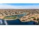 Expansive aerial view of a residential community featuring a lake, golf course, and desert landscape at 42660 W Oakland Dr, Maricopa, AZ 85138