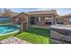 The backyard boasts a pool, hot tub, covered patio, and green artificial grass, creating an outdoor haven at 42660 W Oakland Dr, Maricopa, AZ 85138