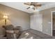 Inviting bedroom showcasing a ceiling fan, plush carpeting, and a comfortable accent chair at 42660 W Oakland Dr, Maricopa, AZ 85138