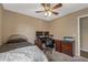 This bedroom features carpeted floors, a ceiling fan, and a built-in desk area with a computer setup at 42660 W Oakland Dr, Maricopa, AZ 85138