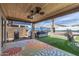 Relaxing covered patio with ceiling fans, grill, hot tub, and vibrant floral rug at 42660 W Oakland Dr, Maricopa, AZ 85138