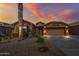 Beautiful single-story home showcasing desert landscaping and a neutral color palette under a vibrant sunset sky at 42660 W Oakland Dr, Maricopa, AZ 85138
