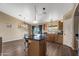 Well-lit kitchen showcasing a center island, wooden cabinets, black countertops and a stunning view at 42660 W Oakland Dr, Maricopa, AZ 85138