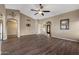 Large living room with wood floors, arched entryways, and bright, open layout at 42660 W Oakland Dr, Maricopa, AZ 85138