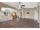 Expansive living room with wood floors, open layout, and views to kitchen and hallways at 42660 W Oakland Dr, Maricopa, AZ 85138