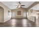 Spacious living room features a vaulted ceiling, modern ceiling fan, and beautiful wood-look floors at 42660 W Oakland Dr, Maricopa, AZ 85138