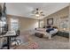 Spacious main bedroom featuring a ceiling fan, carpet floors, natural light, and desk area for convenience at 42660 W Oakland Dr, Maricopa, AZ 85138