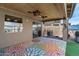 The covered patio features a colorful outdoor rug, ceiling fans, and sliding glass doors for seamless indoor-outdoor living at 42660 W Oakland Dr, Maricopa, AZ 85138