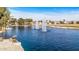Scenic view of a community pond with fountains and lakeside homes with golf course in the background at 42660 W Oakland Dr, Maricopa, AZ 85138