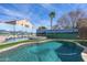 Sparkling pool with custom painted wall, surrounded by green turf and desert landscaping at 42660 W Oakland Dr, Maricopa, AZ 85138
