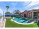 Stunning backyard with a sparkling pool, lush artificial turf, and custom desert landscape mural at 42660 W Oakland Dr, Maricopa, AZ 85138