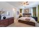 Spacious primary bedroom featuring a ceiling fan, warm color palette, and an ensuite bathroom at 42805 N Hudson Trl, Anthem, AZ 85086