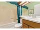 Traditional bathroom with a tub-shower combo, oak vanity, patterned wallpaper, and ample lighting at 459 S Boojum Way, Mesa, AZ 85208