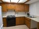 Functional kitchen with oak cabinets, black appliances, and white countertops at 459 S Boojum Way, Mesa, AZ 85208
