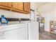Functional laundry room equipped with modern washer, dryer, water heater, and shelving for storage at 459 S Boojum Way, Mesa, AZ 85208